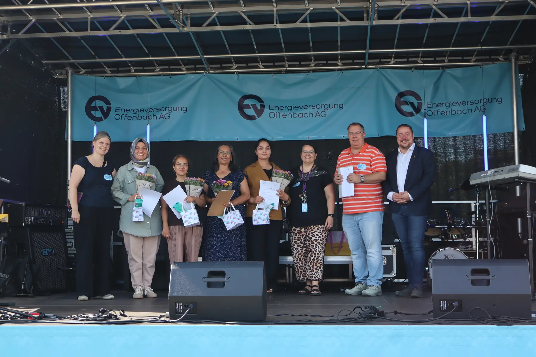 Die vier neuen Integrationslotsinnen stehen mit Mitarbeitenden der Stadt Seligenstadt auf der Bühne des Stadtteilfests.