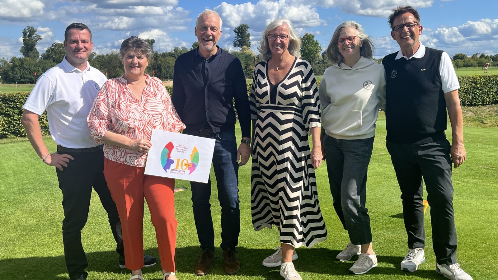 Sechs Personen stehen auf dem Golfplatz des Golfclubs Seligenstadt; eine Frau hält ein ZONTA-Schild.